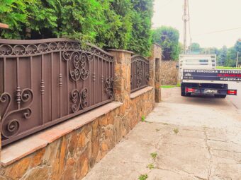 Ogrodzenie kute z wypełnieniem blachą na murowanej podmurówce kamiennej, model OK 047