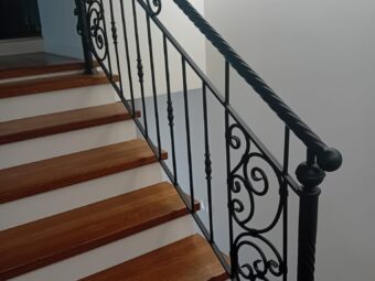 Balustrada kuta wewnętrzna BKW 047 na schodach z drewnianymi stopniami, wzór z esowatych ornamentów