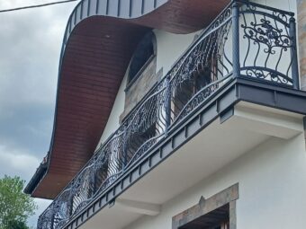 Balustrada balkonowa kuta czarna z prętami skręcanymi i dekoracjami kwiatowymi
