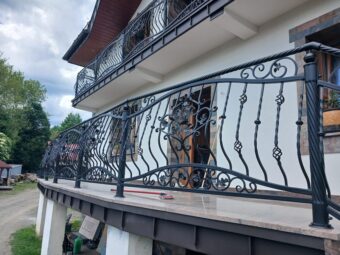 Dwa balkony z kutą balustradą czarną wzór różany